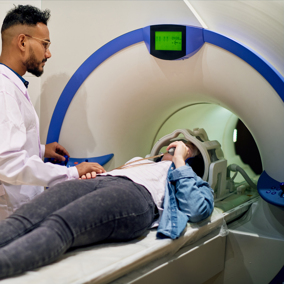 Male doctor prepares female patient for MRI scan.